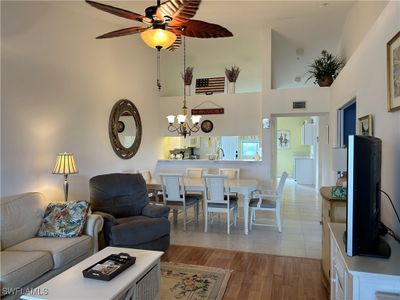 Living room featuring light hardwood title flooring with high vaulted ceiling. | Image 3