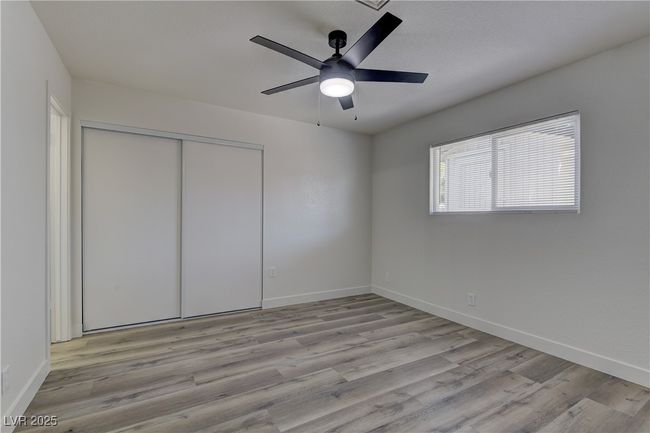 Unfurnished bedroom featuring wood finished floors, a closet, and baseboards | Image 18