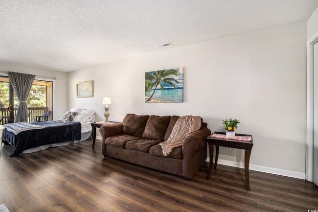 Bedroom with a textured ceiling, dark wood-type flooring, and access to exterior | Image 17