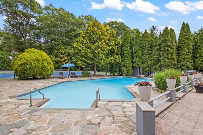 Swimming pool featuring a patio area and view of scattered trees | Image 31