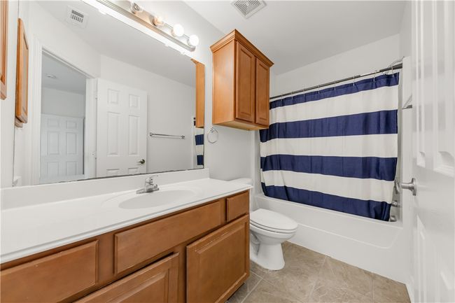 Bathroom featuring shower / tub combo, vanity, visible vents, and toilet | Image 7