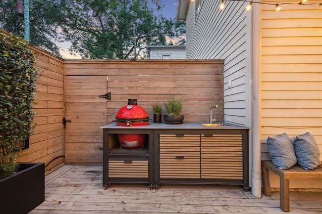 OUTDOOR KITCHEN. Installed in 2021 featuring a ceramic grill and smoker. The gate to the left is the access to a separate area where there is an $18, 000 whole house generator. | Image 34