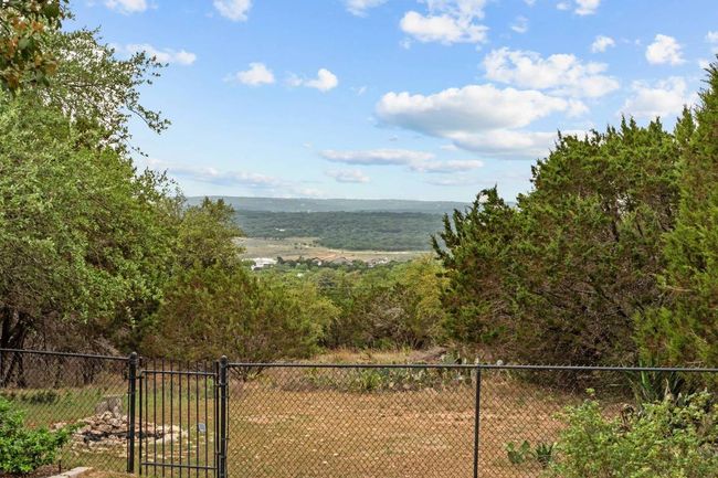 Property view of water featuring a gate, fence, and a wooded view | Image 27
