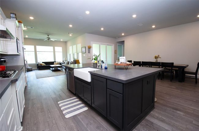 The open-concept kitchen and dining area offers plenty of natural light from the sliding glass doors creating great atmosphere for entertaining. | Image 12
