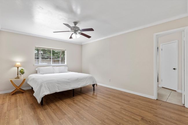 The spacious primary bedroom is a peaceful retreat, offering plenty of room to relax and unwind with natural light streaming through large windows | Image 11