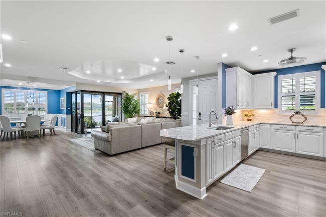 Kitchen with stainless steel dishwasher, a tray ceiling, recessed lighting, white cabinets, and a peninsula | Image 10