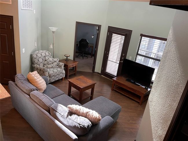 Living area featuring wood finished floors, a desk, and a towering ceiling | Image 24