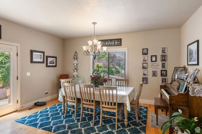 Dining area featuring a chandelier and wood finished floors | Image 9