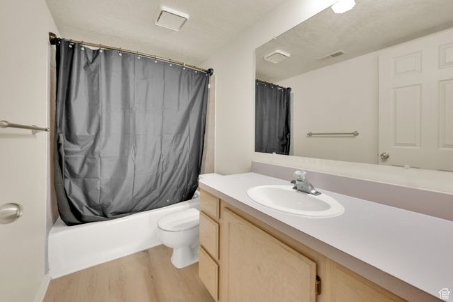 Full bathroom with wood finished floors, vanity, toilet, and shower / bathtub combination with curtain | Image 20