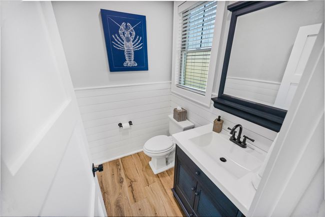 Bathroom with vanity, toilet, a wainscoted wall, wooden walls, and wood finished floors | Image 21