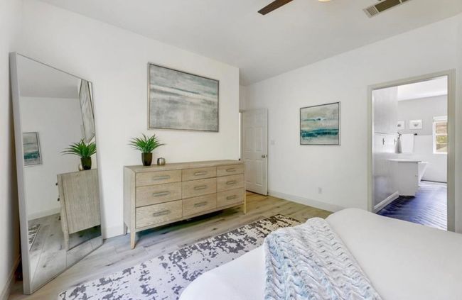 Bedroom with baseboards, visible vents, light wood-style floors, and ensuite bathroom | Image 18