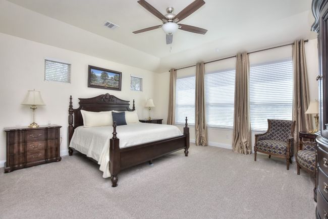 Carpeted bedroom featuring visible vents, baseboards, a ceiling fan, and vaulted ceiling | Image 21