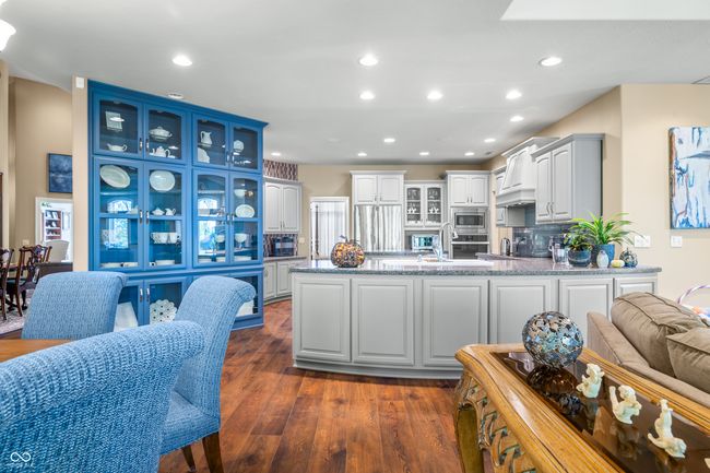 kitchen with dark wood finished floors, recessed lighting, glass insert cabinets, stainless steel appliances, and a peninsula | Image 26