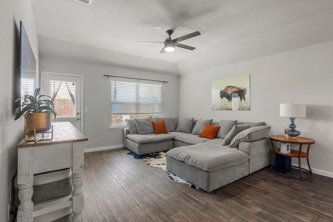 Living area with dark wood-style flooring, a ceiling fan, and a textured ceiling | Image 10