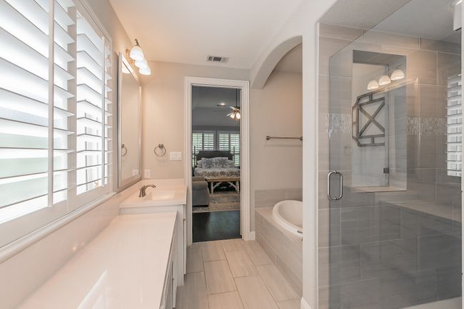 Ensuite bathroom featuring a bath, vanity, a shower stall, a ceiling fan, and tile patterned flooring | Image 19