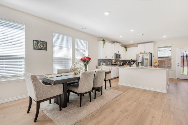 Dining area with light wood-style floors, recessed lighting, visible vents, and baseboards | Image 7