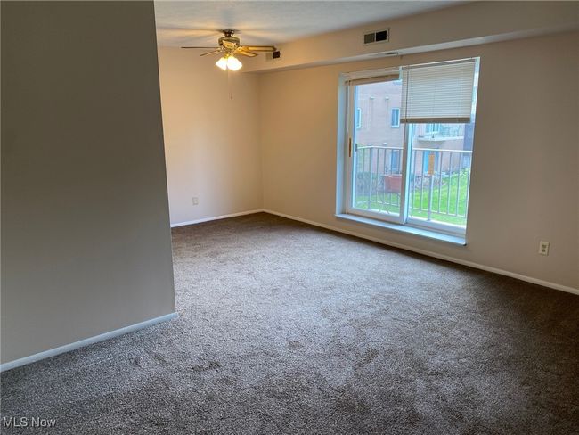 Carpeted spare room featuring baseboards, a ceiling fan, and visible vents | Image 6