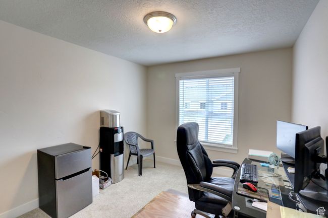Office area with a textured ceiling, carpet flooring, and baseboards | Image 20