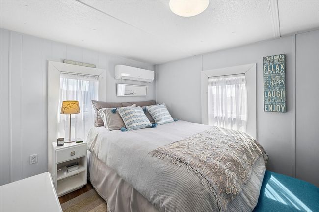 Bedroom with a textured ceiling and a wall unit AC | Image 7
