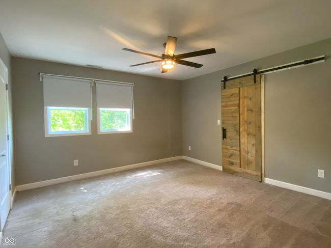 Primary bedroom with sliding barn door entry to the walk in closet | Image 16