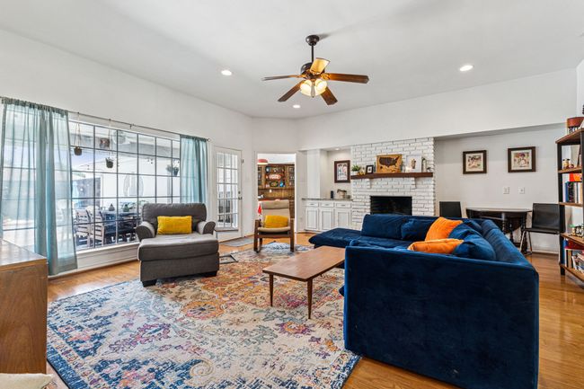 Living area with a ceiling fan, a fireplace, wood finished floors, and recessed lighting | Image 7