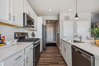 (Photo of a decorated model, actual homes finishes will vary) The mudroom and powder bath are off the kitchen. | Image 3