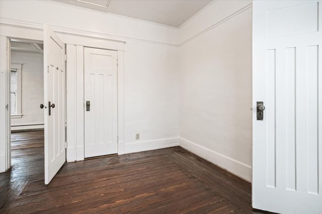Unfurnished room featuring crown molding, baseboard heating, and dark wood-type flooring | Image 15