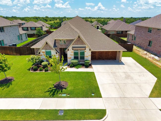 View of front of home featuring driveway, a shingled roof, stone siding, a residential view, and a garage | Image 27