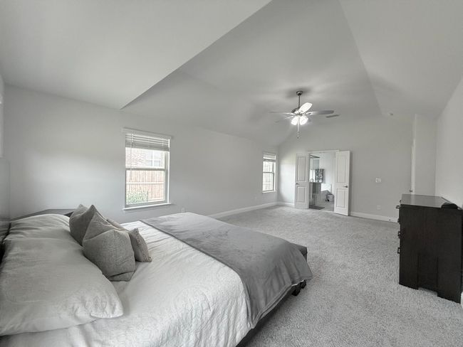 Bedroom featuring vaulted ceiling, carpet floors, and ceiling fan | Image 12