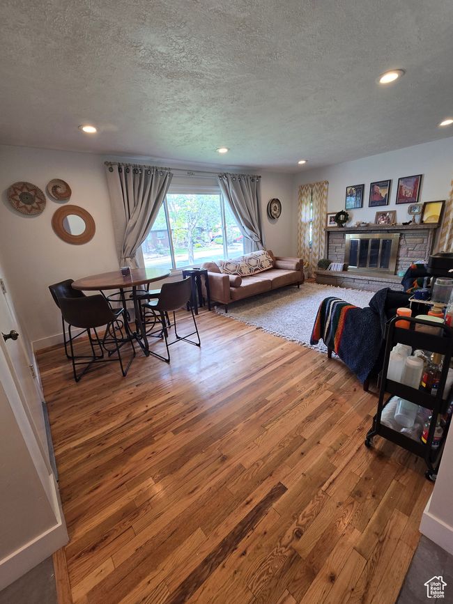Living room with wood-type flooring, recessed lighting, a textured ceiling, and baseboards | Image 13
