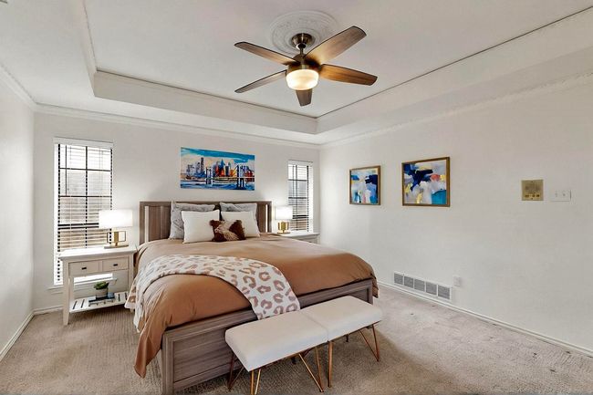 Bedroom with a raised ceiling, carpet floors, crown molding, and ceiling fan | Image 16