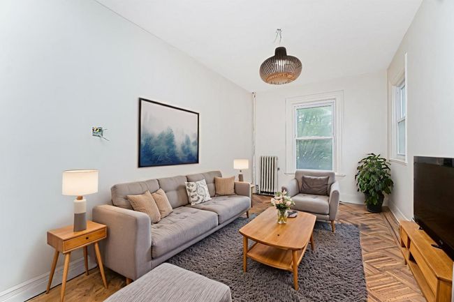 Living room featuring radiator heating unit and baseboards | Image 4