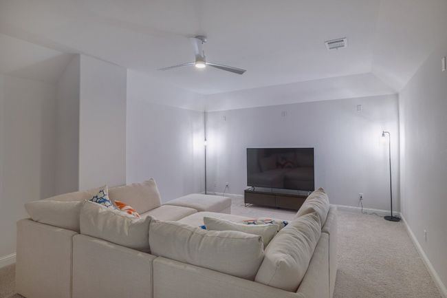 Living area featuring light colored carpet, a ceiling fan, and baseboards | Image 23
