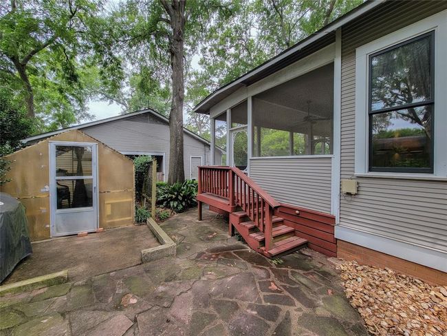 Charming flagstone patio paired with a spacious greenhouse, ideal for cultivating herbs and plants. | Image 33