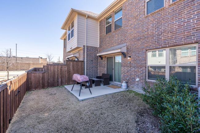 Back of property with brick siding, a fenced backyard, and a patio | Image 20