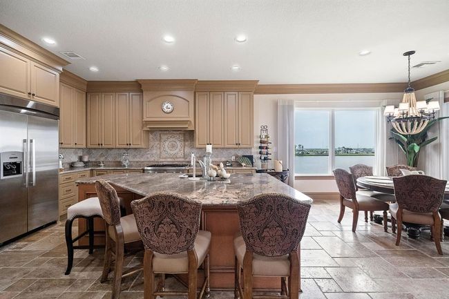 The kitchen features a spacious breakfast bar, perfect for casual dining or entertaining guests | Image 15