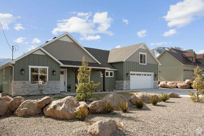 Craftsman house with concrete driveway, an attached garage, board and batten siding, stone siding, and roof with shingles | Image 40