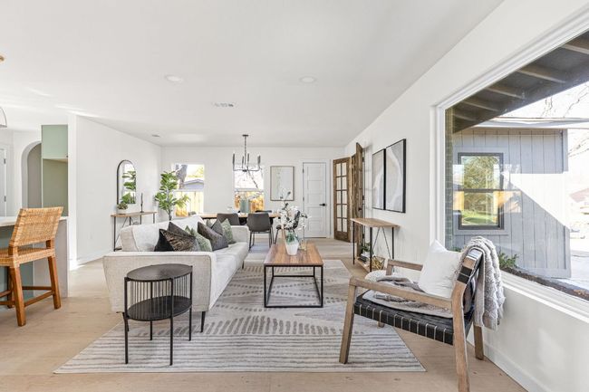 Living room with a chandelier, light wood finished floors, arched walkways, and recessed lighting | Image 4