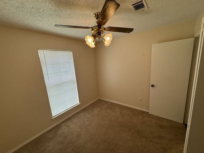 Carpeted bedroom room featuring ceiling fan and a textured ceiling | Image 19