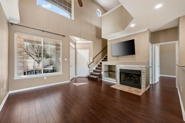 Unfurnished living room featuring crown molding, recessed lighting, wood flooring, a fireplace with flush hearth, and gas logs. | Image 11
