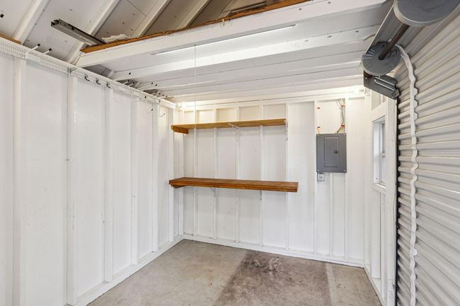 Shed interior is painted, has electricity and shelving and lofted storage. | Image 34