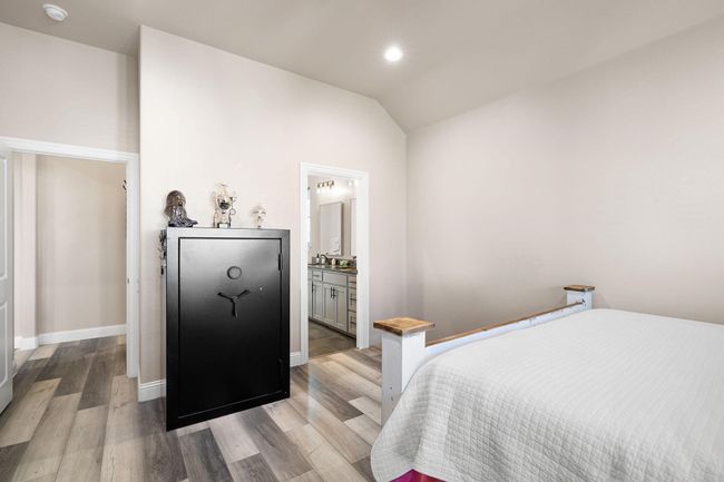 Bedroom featuring recessed lighting, ensuite bath, vaulted ceiling, light wood finished floors, and baseboards | Image 19