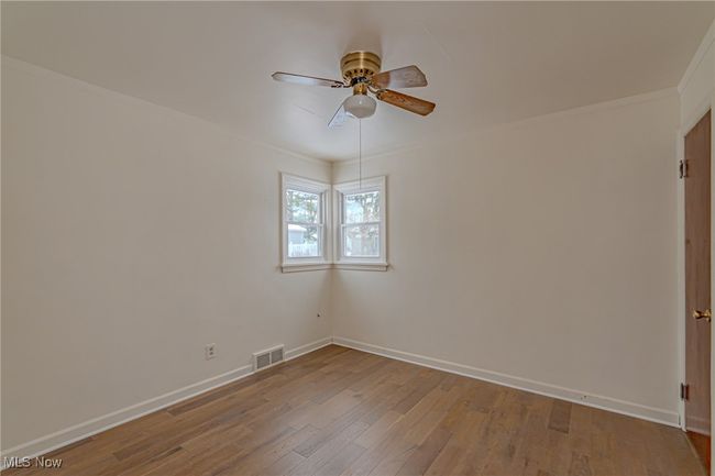 Empty room with light hardwood / wood-style floors, ceiling fan, and ornamental molding | Image 9