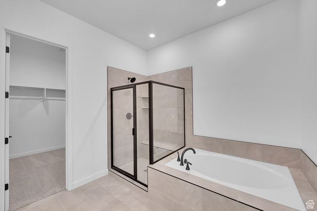 Full bathroom featuring a bath, a spacious closet, a stall shower, recessed lighting, and tile patterned flooring | Image 15
