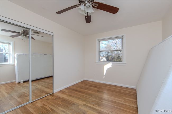 Unfurnished bedroom with ceiling fan, multiple windows, and light hardwood / wood-style flooring | Image 22