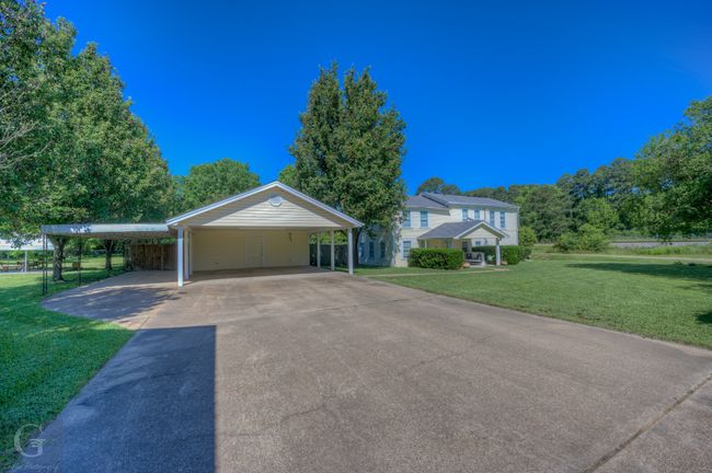 View of front of house with a front yard, asphalt driveway, and a carport | Image 4