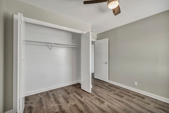 Unfurnished bedroom featuring wood finished floors, a closet, baseboards, and ceiling fan | Image 15