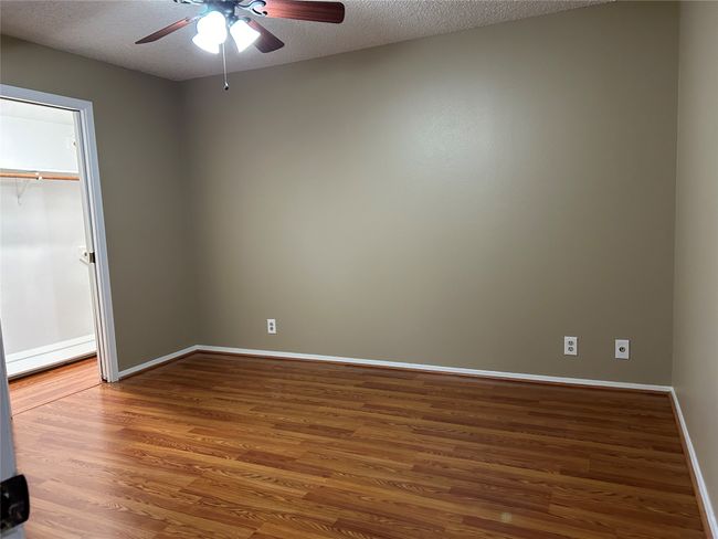 Empty room featuring a textured ceiling, ceiling fan, and wood-type flooring | Image 24