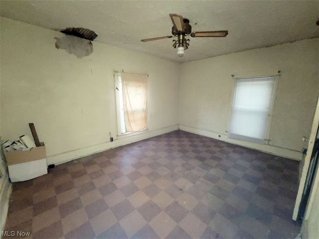 Empty room featuring ceiling fan and dark tile flooring | Image 11