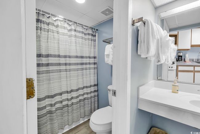 Bathroom featuring wood finished floors, curtained shower, and vanity | Image 13